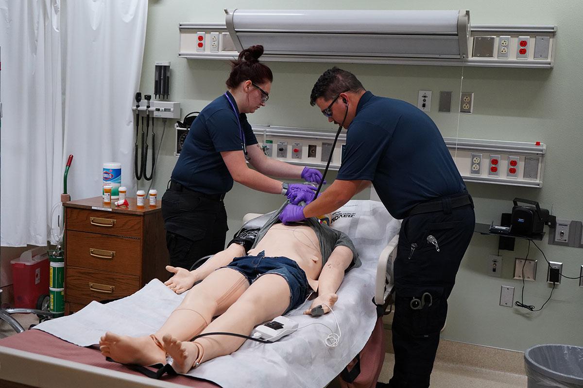 Students in the simulation lab intubating one of the small simulation dummies.